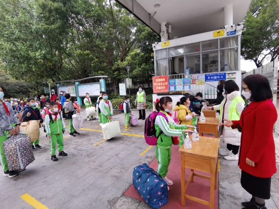 已处理10  沙坪六小的同学们保持1米线距离在校门口进行手部消毒，有序进校园.jpg